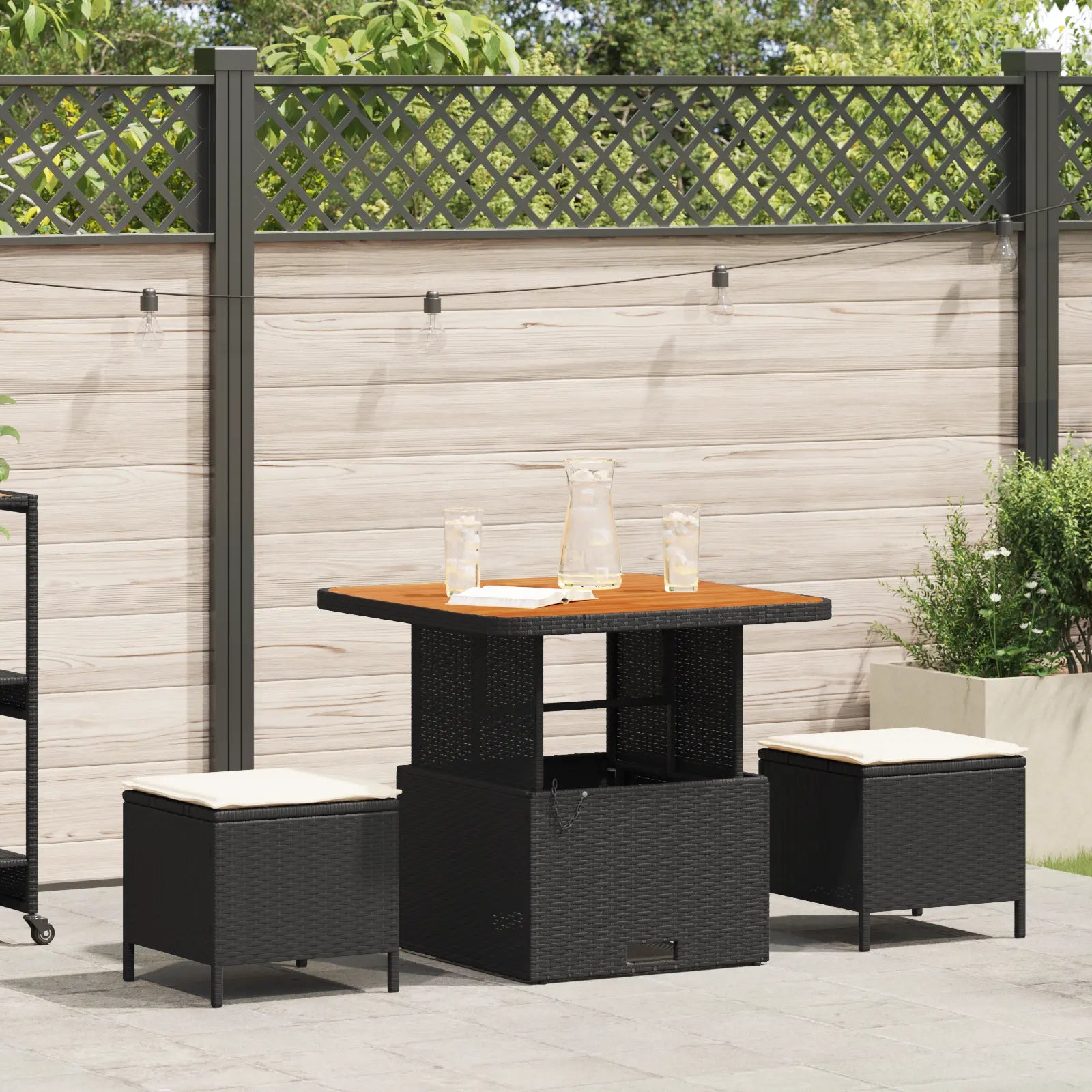 salle à manger de jardin en rotin noir avec coussins crème