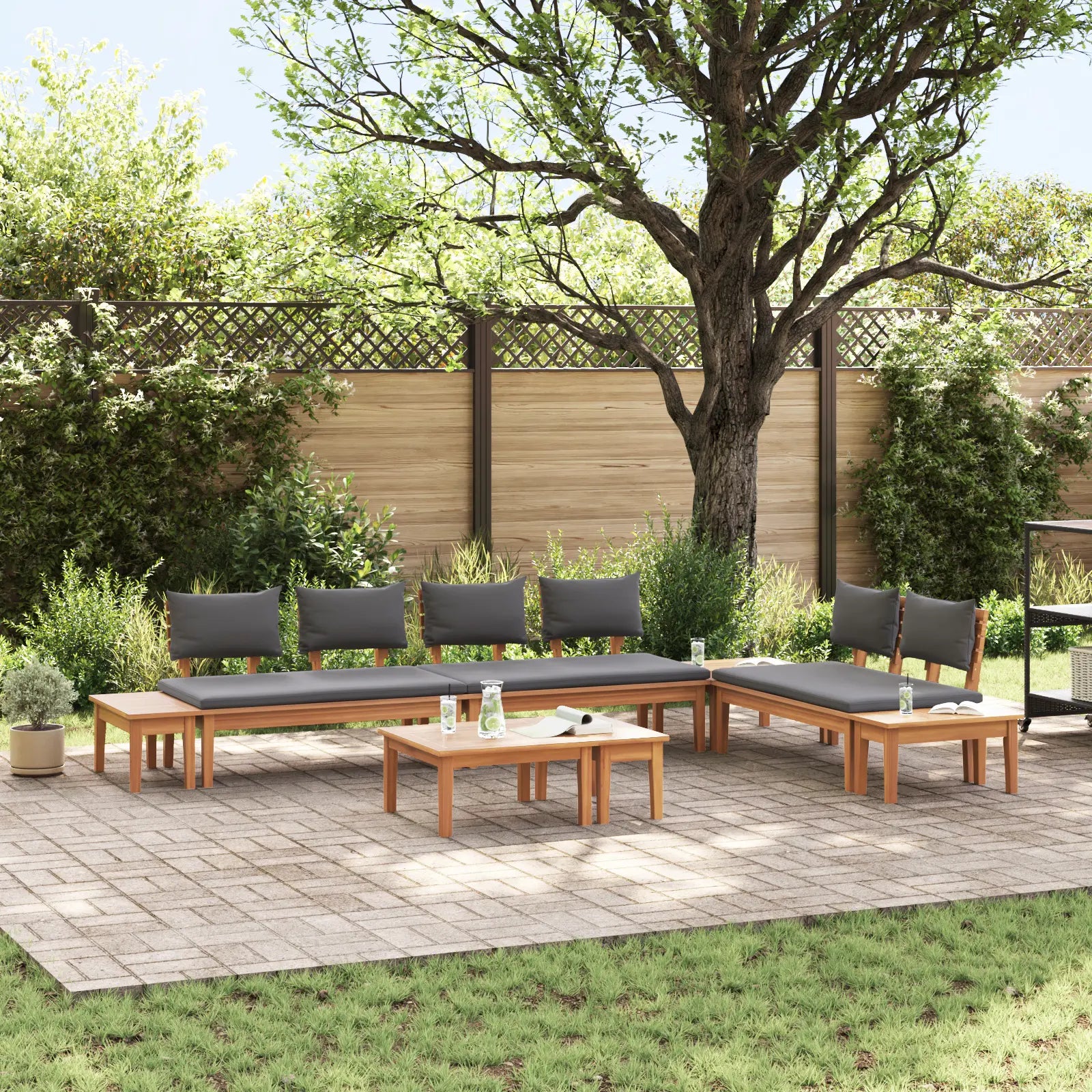 Salon de jardin en teck avec coussins crème sur terrasse boisée.