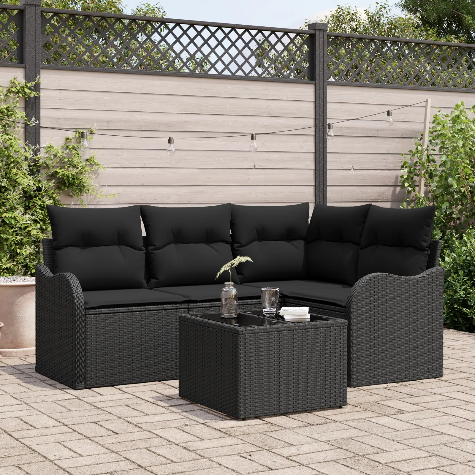 Salon modulable en résine tressée noire sur terrasse.