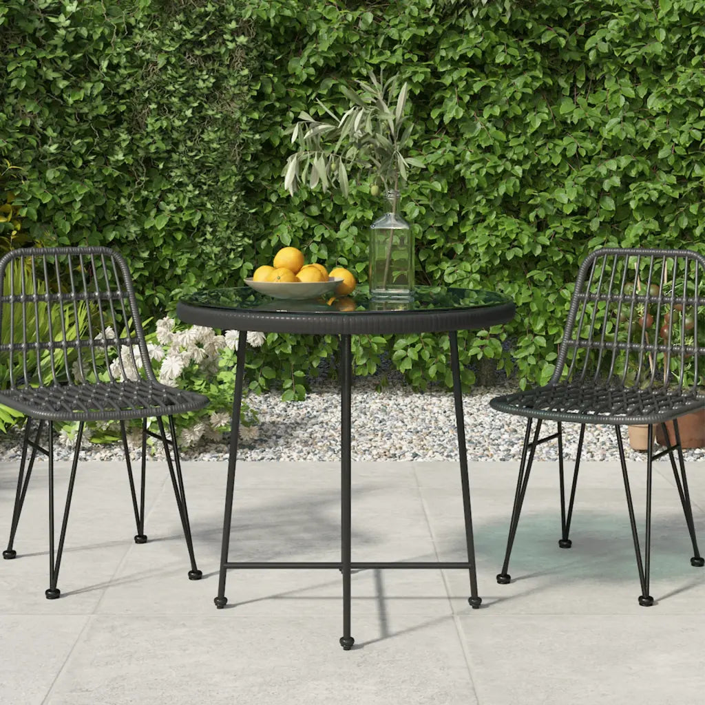 Table de jardin ronde 80 cm en rotin noir avec plateau verre trempé dans un jardin
